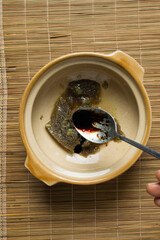 Overhead view of a spoon of soy sauce, top view of dark soy sauce in a silver spoon