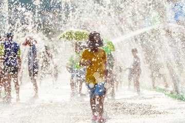 Children playing among the stream of water pouring from the park's floor fountain in the summer