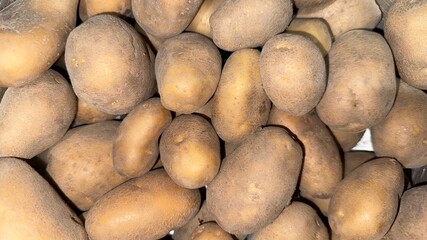 Full frame presents a heap of brown potatoes displaying their natural textures and shapes