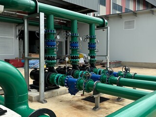 Industrial cooling tower system with metal piping, heat exchangers, and elevated pipe racks under...