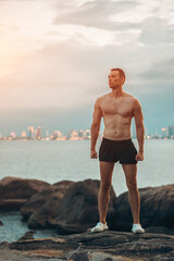 Athlete on rock showcases strength and nature challenge, Muscular athletic climber man at mountain peak radiates fitness and rugged success