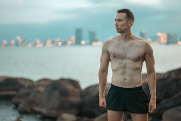 Athlete on rock showcases strength and nature challenge, Muscular athletic climber man at mountain peak radiates fitness and rugged success