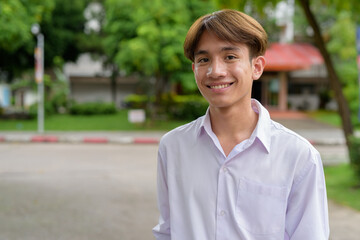 Non binary university student smiling in college campus