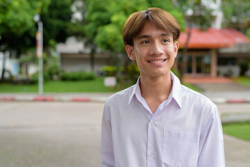 Obraz premium Non binary university student smiling in college campus