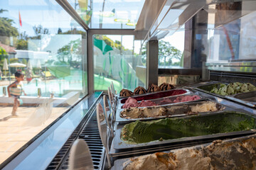 A display of ice cream with a child playing in the background. Scene is lighthearted and playful