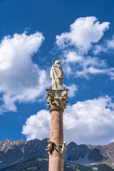Close view of St. Anne's Column on Maria Theresien Street in center of Innsbruck with Nordkette mountain in background in spring, Tyrol, Austria