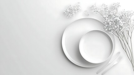 White tableware and flowers on a white surface