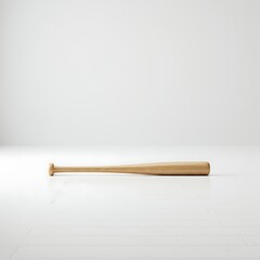 A light-colored wooden baseball bat lies horizontally on a white floor in a minimalist studio setting.