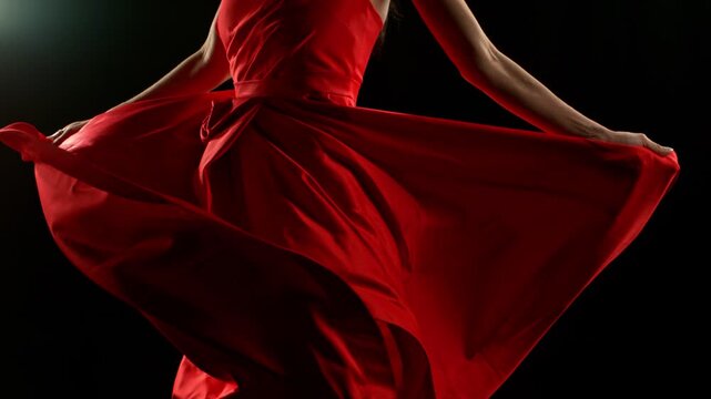 Brunette Woman in Ruby Red Dress Posing Against a Black Background . Filmed on High Speed Cinematic Camera in Super Slow Motion