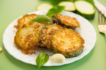 Crispy zucchini slices in sesame on a white plate