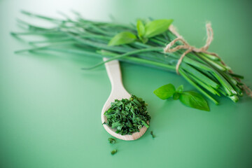 Natural seasonings from greens and onions on green background