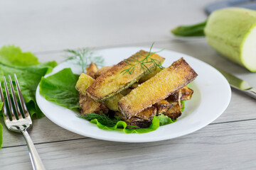 Fried zucchini slices with salad greens