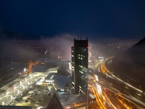 Aerial view of a towering skyscraper piercing through the misty night sky, illuminated by city lights near Na Trosk&Atilde;&iexcl;ch, Bansk&Atilde;&iexcl; Bystrica, Banskobystrick&Atilde;&frac12; kraj, Slovakia.