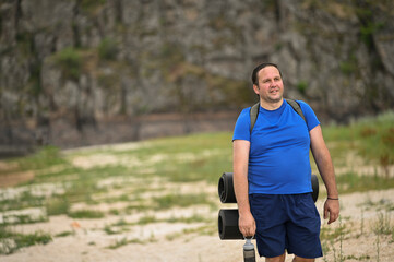 Fototapeta premium a tourist with a backpack walks along the river beach