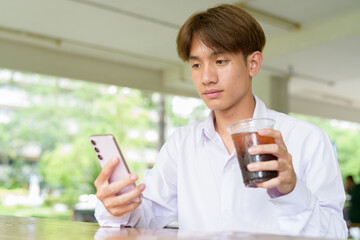Non binary university student sitting in college campus