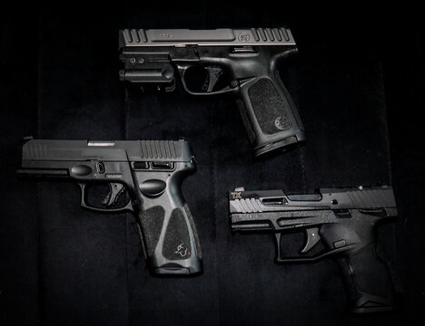 three compact self-defense 9mm and 22LR handgun firearms Smith and Wesson, Taurus guns.