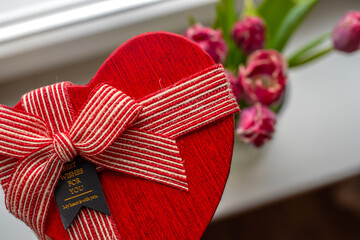 Heart-shaped gift box with striped ribbon and 