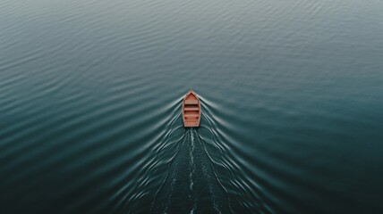 Wooden boat sailing on calm blue water creating ripples from above view