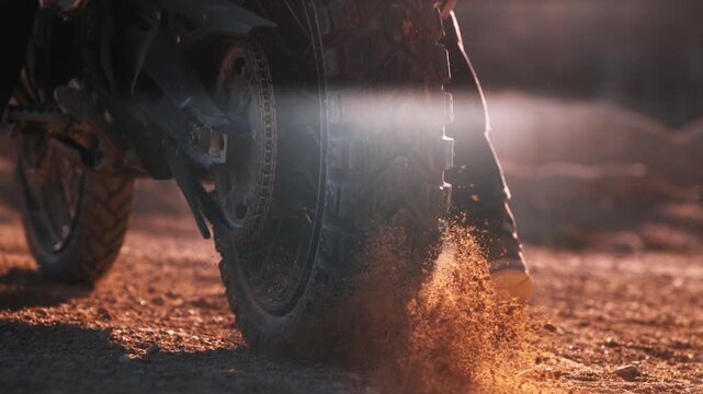 Super slow motion of flying rocks and dust from the wheel of a motocross bike at the start of the race