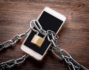 smartphone security with chain and padlock on wooden surface