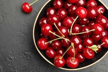 Fresh ripe cherries on black table, top view