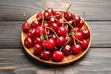 Fresh ripe cherries on black wooden table, closeup