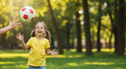 Young girl playing with a soccer ball in park during summer