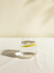 a cold clear glass of lemonade on the table illuminated by a bright light