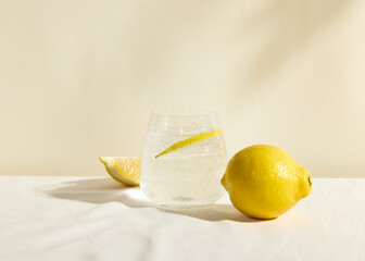 a cold clear glass of lemonade on the table illuminated by a bright light