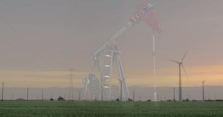 Pumping oil pump jack moving beam on field at sunset, with wind turbines and transmission towers