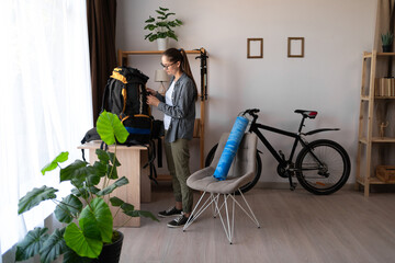 hiking, preparing a backpack for a mountain trip, a female hiker getting ready for a nature tour at...