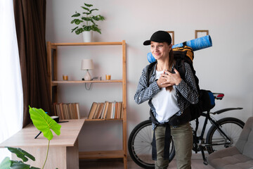 sincere female traveler hiker with backpack ready to travel holding folded hands on chest....