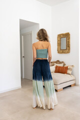 Blonde model posing in the living room wearing a summer outfit.