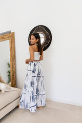 Latina model posing in the living room wearing a summer outfit.
