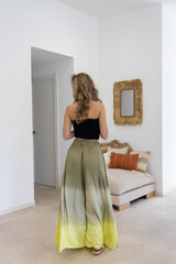 Blonde model posing in the living room wearing a summer outfit.