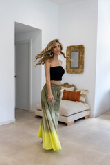 Blonde model posing in the living room wearing a summer outfit.
