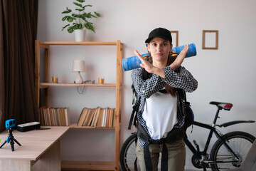 Young woman ready with backpack to go to travel showing a cross with her arms.