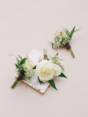 Elegant white roses and greenery displayed on a neutral background for a floral arrangement in...