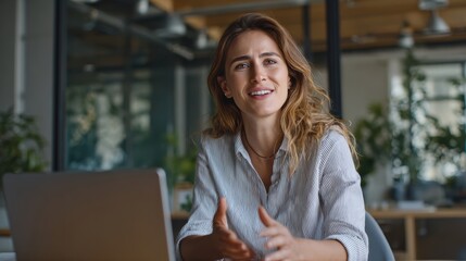 A professional woman engages in a video call, showcasing effective communication in a modern office environment.