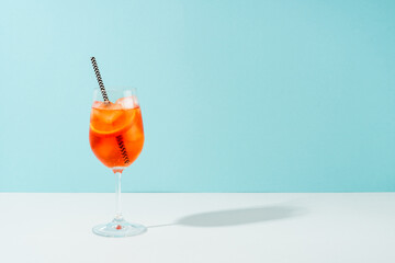 Aperol Spritz, traditional summer cocktail at blue background.