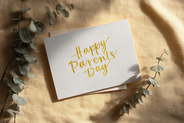 Happy parents day greeting card with gold script lettering and eucalyptus leaves