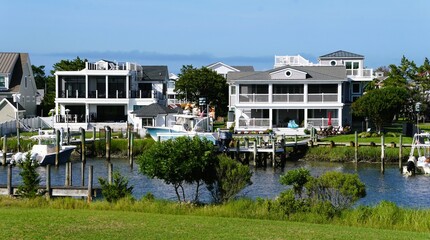 The luxurious waterfront properties, complete with docks and boats, create a serene and desirable...