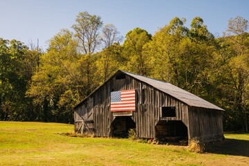Obraz premium Rustic Barn with American Flag