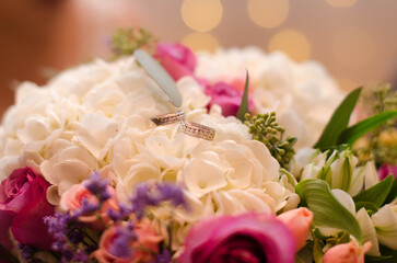bouquet of roses with wedding rings close up