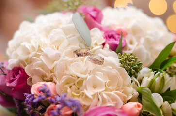 bouquet of roses with wedding rings close up