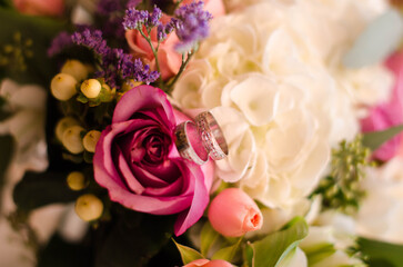 bouquet of roses with wedding rings close up