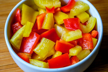 A Bowl Of Fresh Chopped Raw Uncooked Yellow And Red Peppers