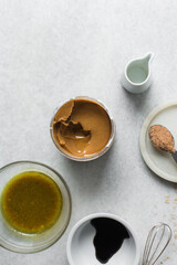 Overhead of ingredients for making peanut butter sauce, mise en place of ingredients for making creamy peanut sauce soy sauce sugar vinegar, process of making peanut sauce 
