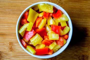 A Bowl Of Fresh Chopped Raw Uncooked Yellow And Red Peppers