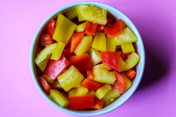 A Bowl Of Fresh Chopped Raw Uncooked Yellow And Red Peppers